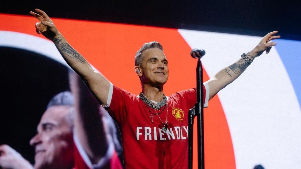 Robbie Williams flaunting weight loss at a concert in Lisbon.
